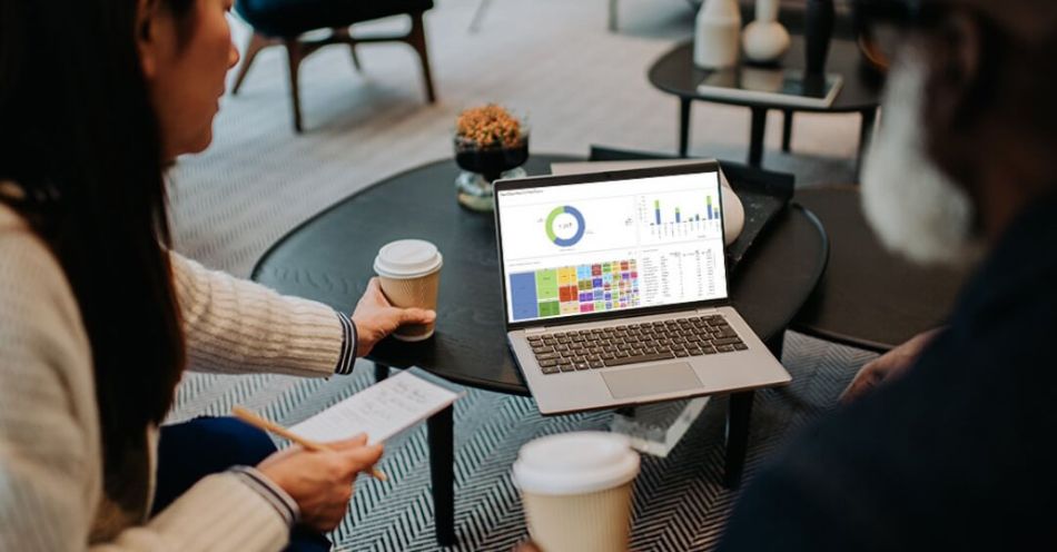 A person working on a laptop with a financial dashboard displayed